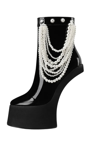 Black high-heeled shoe with pearl embellishments on a white background
